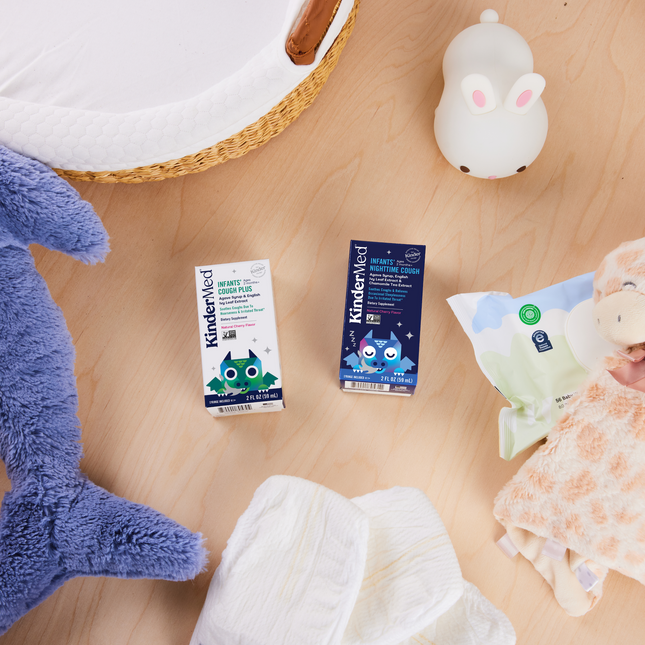 A birds-eye-view image of KinderMed products sitting amongst children's toys and supplies such as diapers and wipes.