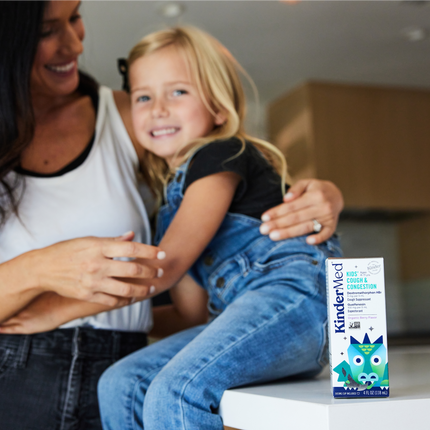 Image of a small child smiling with he mother, and product packaging in the foreground.